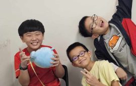 Three students measuring a blue soft toy