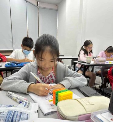 Primary 5 student solving a math problem during a lesson